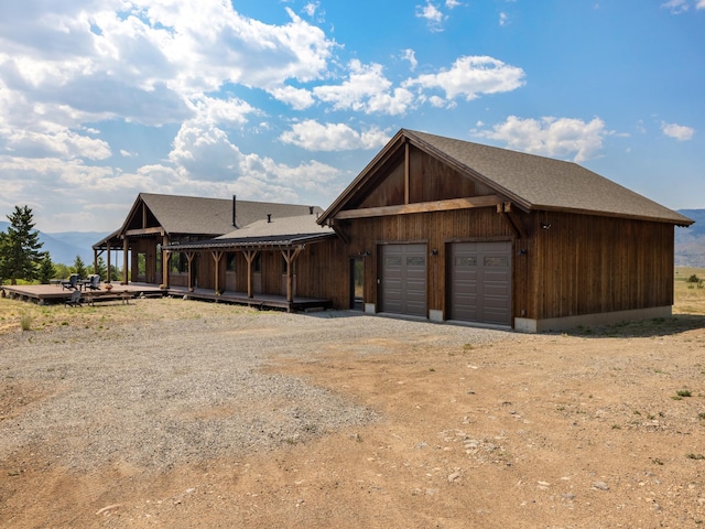 view of front of home with driveway and roof with shingles