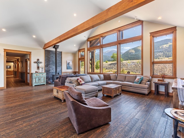 living room with a wood stove, a mountain view, dark wood-type flooring, and beam ceiling