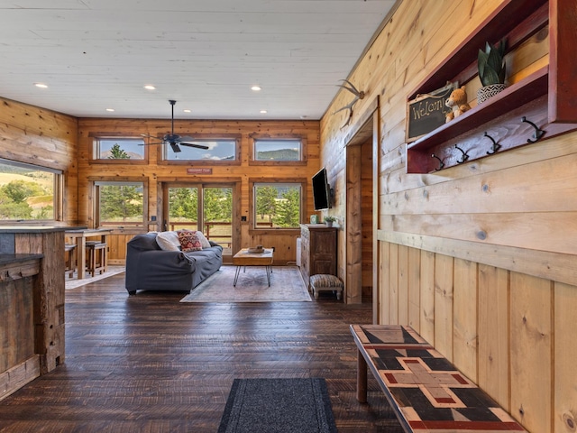 living area featuring a wealth of natural light, wooden walls, recessed lighting, and wood finished floors