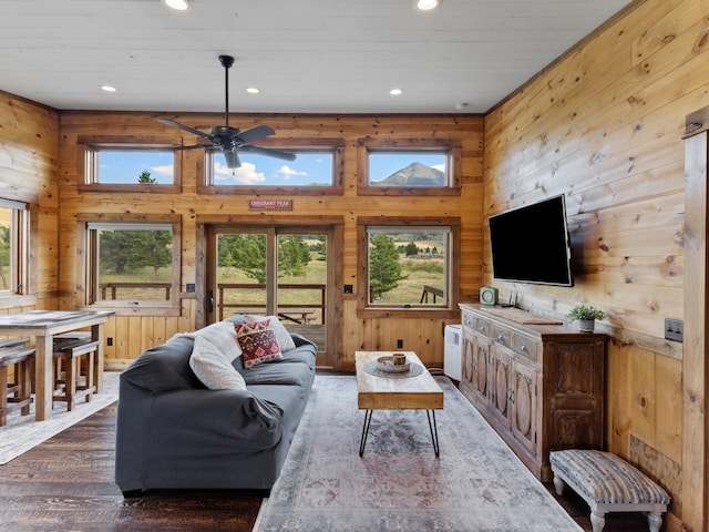 living area featuring wooden walls, a ceiling fan, wood finished floors, and recessed lighting