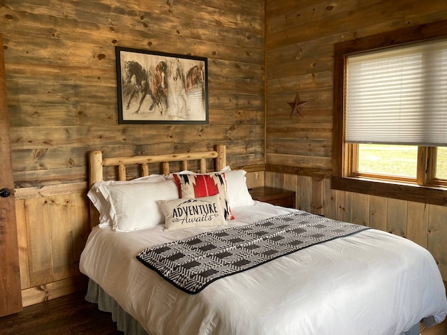 bedroom featuring wood finished floors and wooden walls