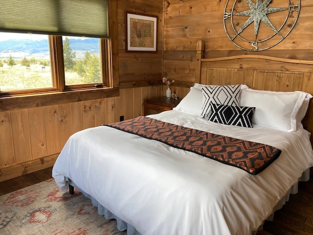 bedroom with wood finished floors and wooden walls