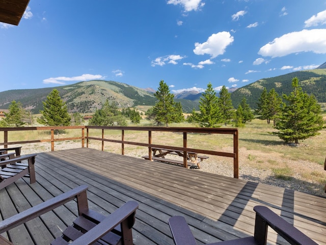 wooden terrace with a rural view and a mountain view