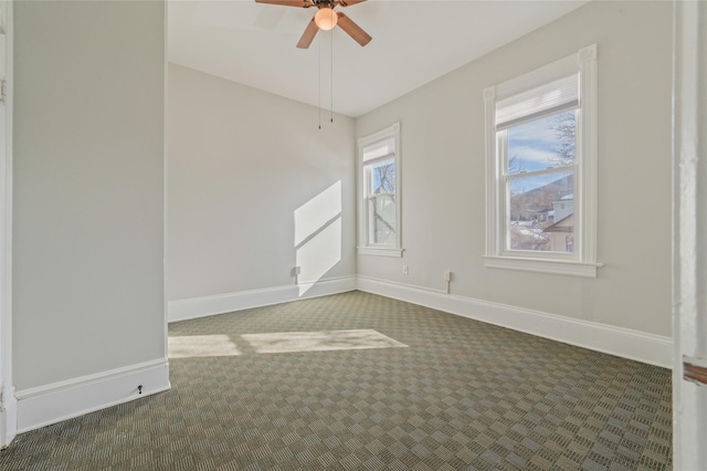 spare room with a ceiling fan, carpet, and baseboards