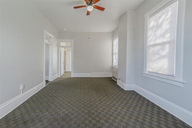 empty room with carpet, ceiling fan, and baseboards