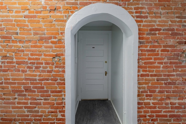 doorway to property with brick siding