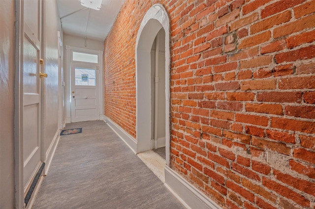 hallway with arched walkways and brick wall