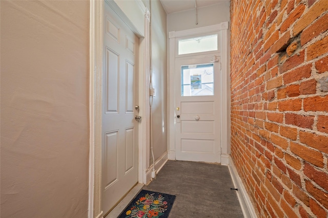 doorway to outside featuring brick wall