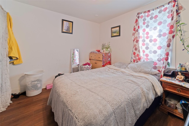 bedroom with baseboards and wood finished floors