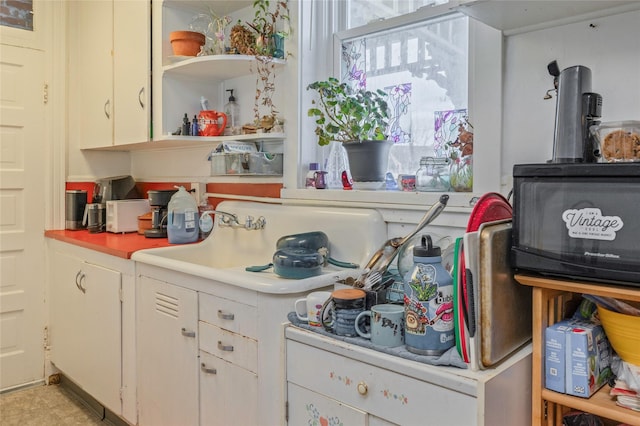 kitchen with white cabinets, light countertops, and open shelves