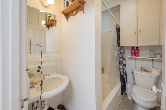 bathroom featuring toilet, a sink, and shower / tub combo with curtain