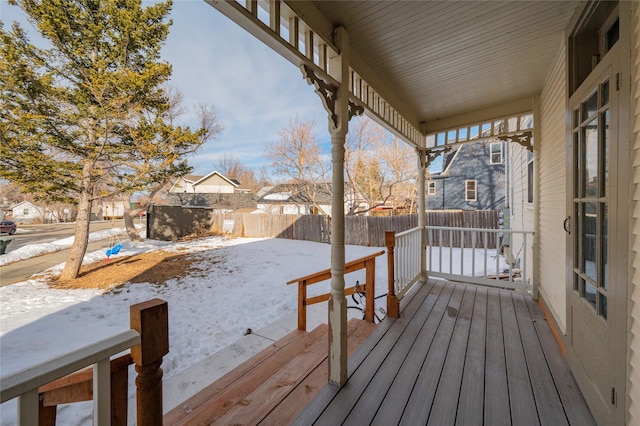 snow covered deck featuring fence