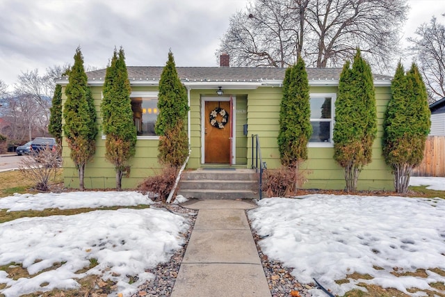 view of front of house featuring a chimney and fence