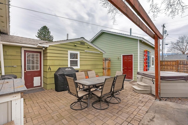 view of patio with a hot tub, fence, a grill, and outdoor dining area