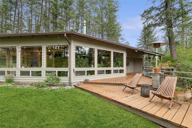 rear view of property with a wooden deck and a yard