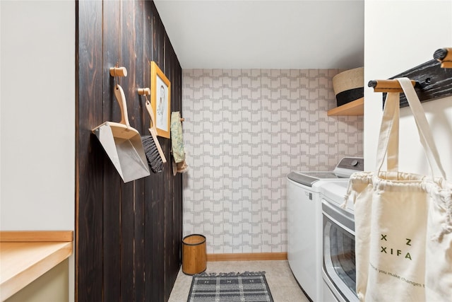 clothes washing area with washer and dryer, baseboards, and laundry area