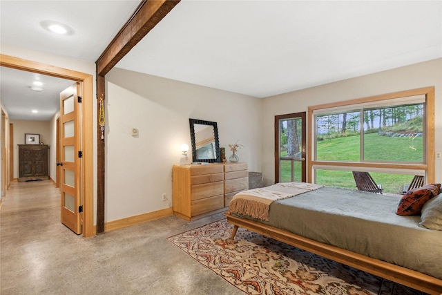 bedroom featuring beam ceiling, finished concrete floors, and baseboards