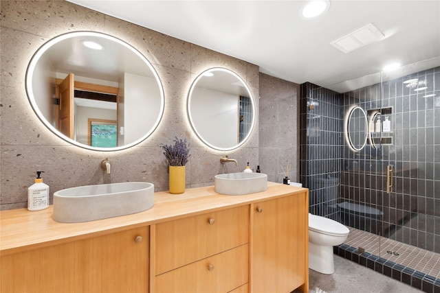 full bath featuring tile walls, toilet, a stall shower, and a sink