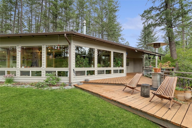 rear view of property with a yard and a deck