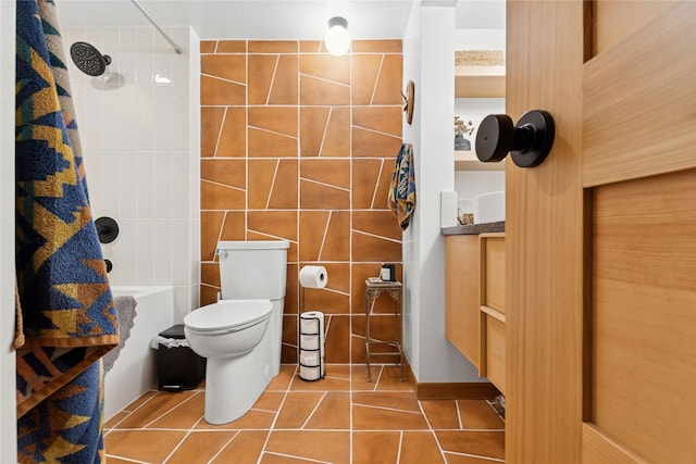 bathroom with tile patterned floors, toilet, and tile walls