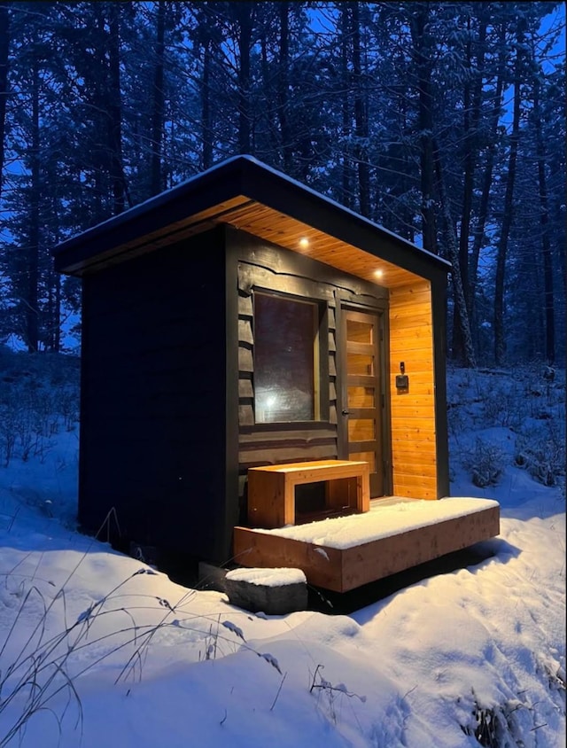 snow covered structure with an outdoor structure