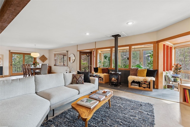 living room with a wood stove, recessed lighting, and a healthy amount of sunlight