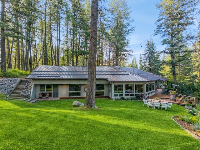 456 Peaceful Dr, Bigfork, MT 59911 - back of house with stairs, a deck, a lawn, and a metal roof