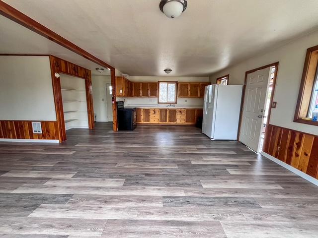 116 Happy Holw, Eureka, MT 59917 - kitchen featuring freestanding refrigerator, open floor plan, dark wood finished floors, brown cabinets, and light countertops
