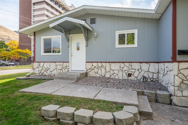 property entrance with crawl space and a yard