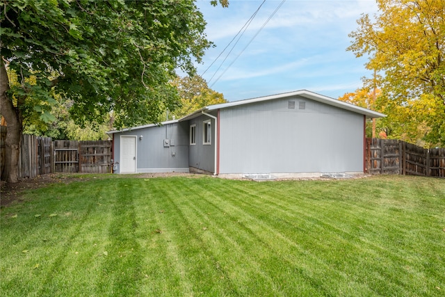 rear view of property featuring a fenced backyard and a yard