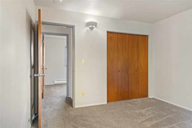 unfurnished bedroom with baseboards, carpet, a baseboard heating unit, and a closet