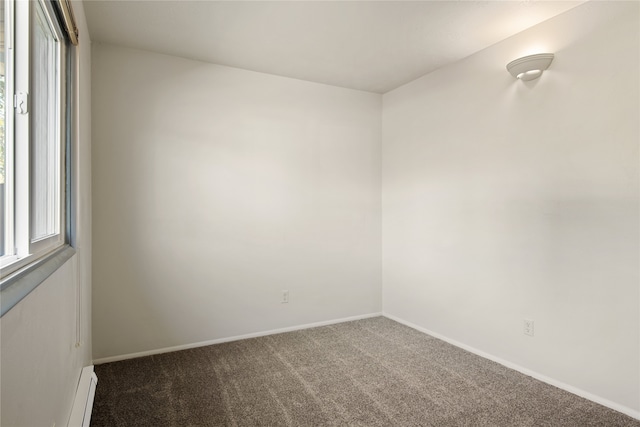 carpeted spare room featuring baseboards