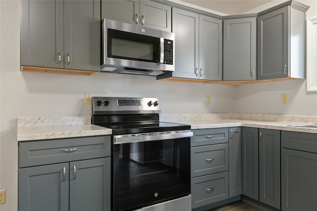 kitchen featuring stainless steel appliances and gray cabinets