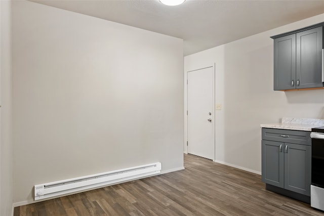 unfurnished dining area with dark wood-style flooring, baseboards, and baseboard heating