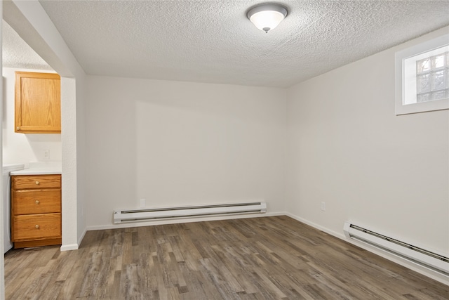 interior space with a baseboard radiator, a textured ceiling, and wood finished floors