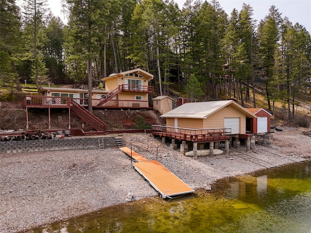 237 Lake Blaine Dr, Kalispell, MT 59901 - back of property featuring a deck with water view, an outdoor structure, and stairs