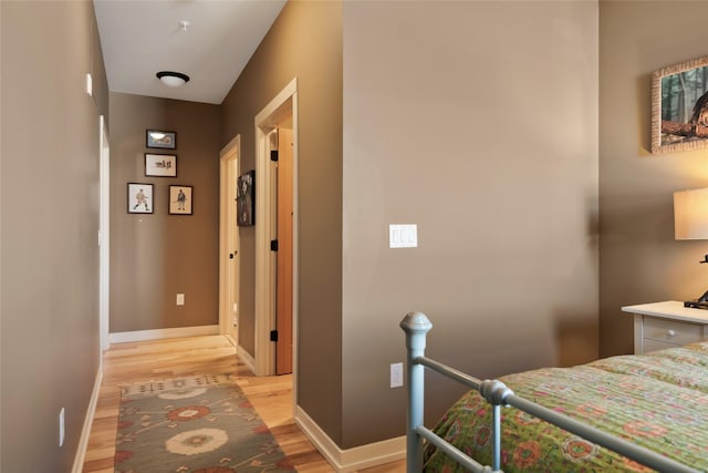 bedroom featuring light wood finished floors and baseboards