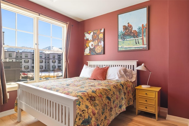 bedroom with baseboards and wood finished floors