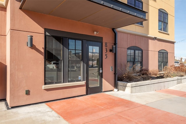 doorway to property featuring a patio and stucco siding