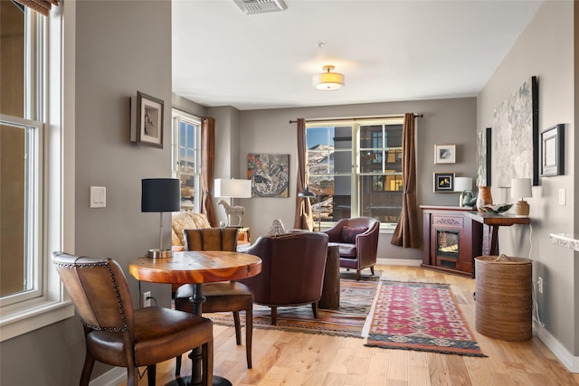 living area with visible vents, baseboards, and wood finished floors