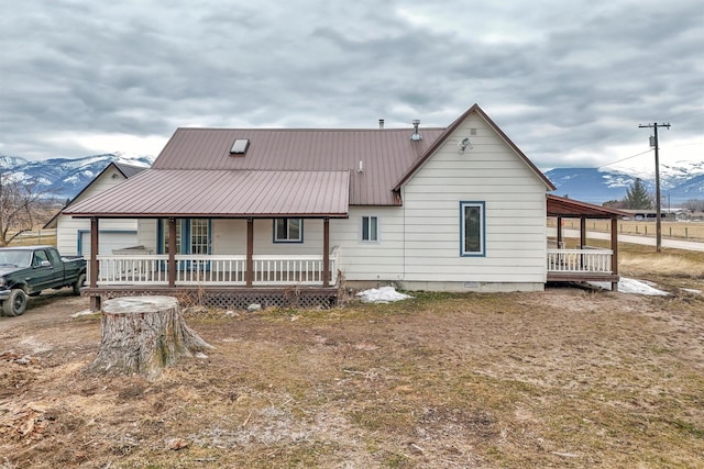 back of property featuring crawl space, covered porch, and metal roof