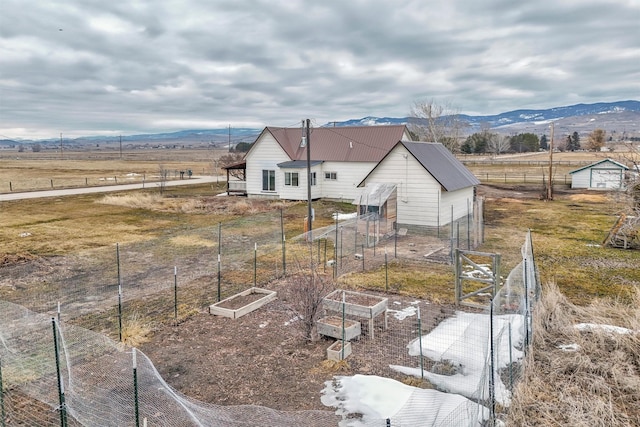 view of yard with a mountain view, a rural view, a vegetable garden, and fence