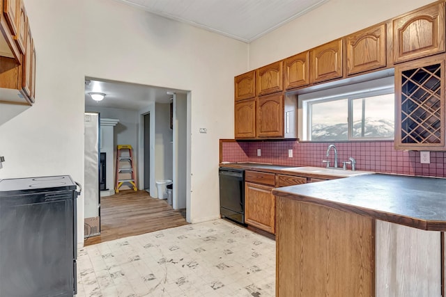 kitchen featuring brown cabinets, decorative backsplash, a sink, dishwasher, and a peninsula