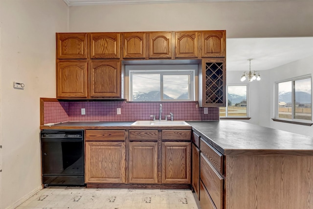 kitchen featuring dishwasher, brown cabinets, a peninsula, a sink, and backsplash