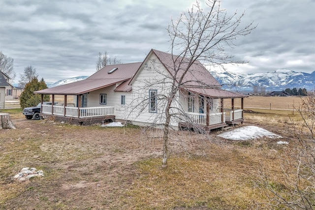 rear view of house featuring metal roof and a deck with mountain view