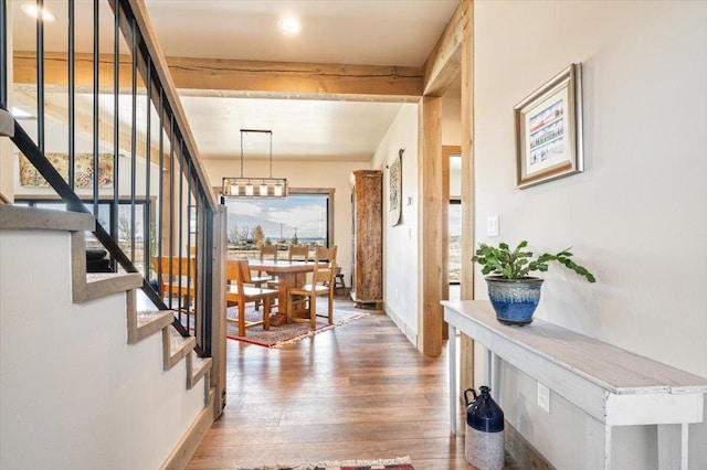 interior space with stairs, beam ceiling, baseboards, and wood finished floors