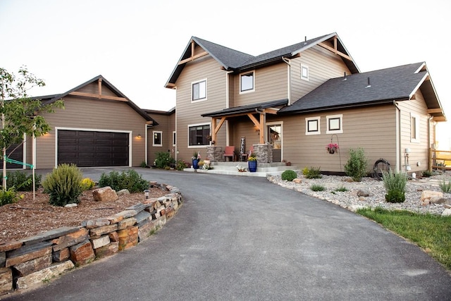 craftsman inspired home featuring aphalt driveway and an attached garage