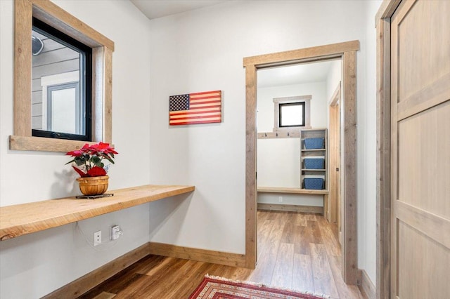 hallway with wood finished floors and baseboards