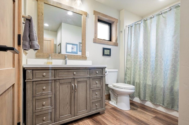 full bath featuring toilet, wood finished floors, and vanity