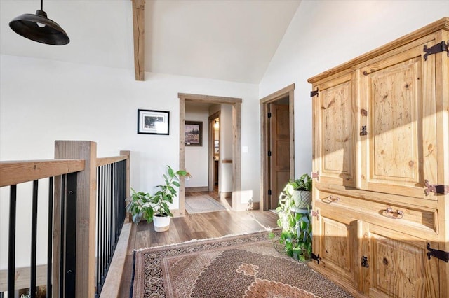 corridor featuring vaulted ceiling with beams, baseboards, and wood finished floors